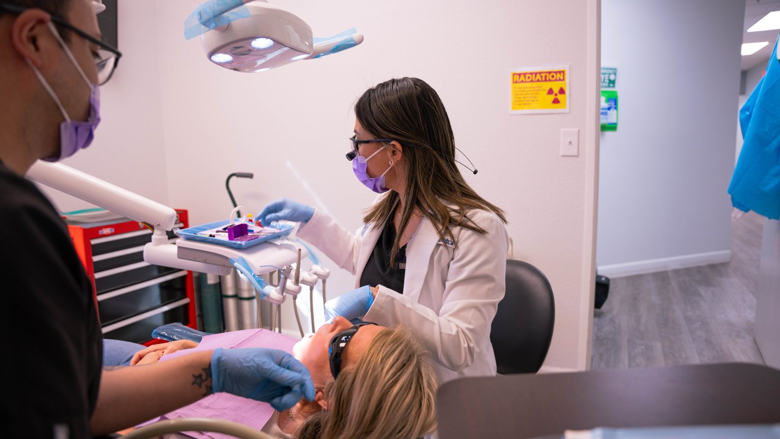 The Dental Implant Process: What Families Need to Know 1 Dr. Christine Navales and an assistant treating a patient at Adco Dental in Las Vegas